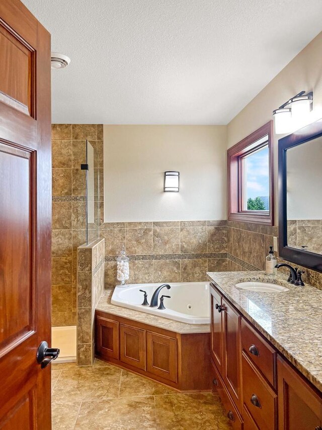 5634 Wind Dancer Ct, Sheboygan, WI 53081 - bathroom with a walk in shower, a jetted tub, vanity, a textured ceiling, and tile patterned floors