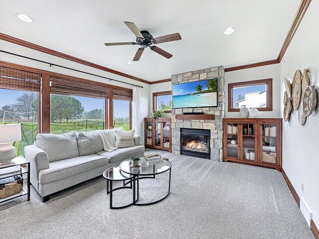 5634 Wind Dancer Ct, Sheboygan, WI 53081 - living area with carpet flooring, crown molding, a stone fireplace, a ceiling fan, and baseboards