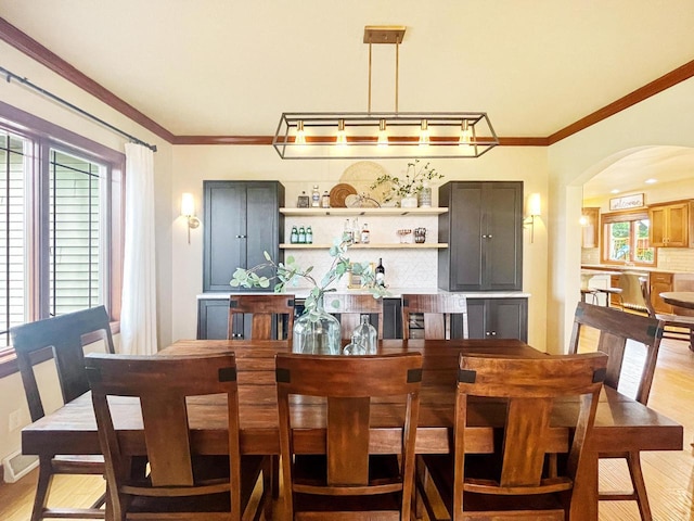 5634 Wind Dancer Ct, Sheboygan, WI 53081 - dining area featuring arched walkways, light wood-type flooring, healthy amount of natural light, and ornamental molding