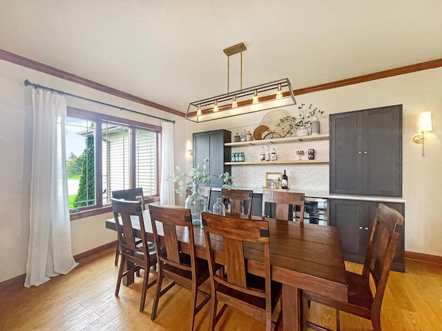 5634 Wind Dancer Ct, Sheboygan, WI 53081 - dining room with light wood-style floors, crown molding, and baseboards