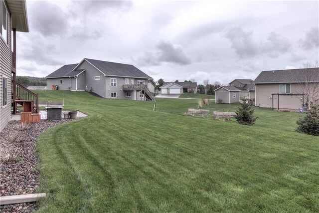 1215 Brooke Ct, Chippewa Falls, WI 54729 - view of green lawn with stairway, an outdoor structure, a deck, and a residential view