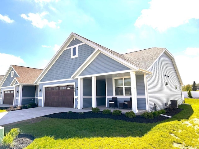 265 Victory Ln, Elkhart Lake, WI 53020 - view of front of home featuring a porch, a front yard, an attached garage, driveway, and central AC