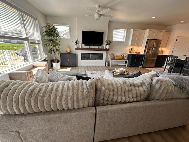 265 Victory Ln, Elkhart Lake, WI 53020 - living room featuring wood finished floors, a glass covered fireplace, a ceiling fan, and recessed lighting