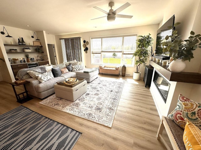 265 Victory Ln, Elkhart Lake, WI 53020 - living room featuring light wood finished floors, a ceiling fan, and a fireplace