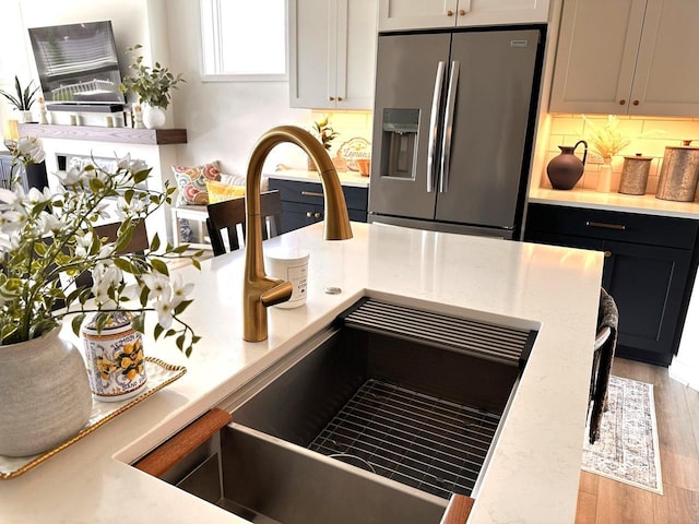 265 Victory Ln, Elkhart Lake, WI 53020 - kitchen with stainless steel refrigerator with ice dispenser, a sink, light wood-style flooring, and light stone countertops