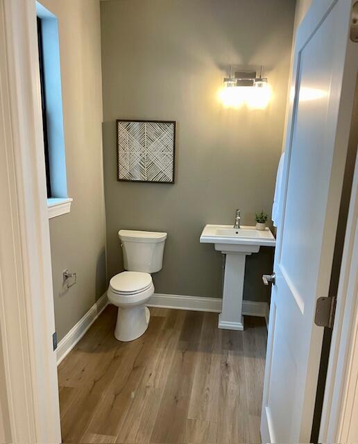 1746 N River Cir, River Hills, WI 53217 - half bath featuring toilet, wood finished floors, baseboards, and a sink