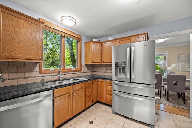 530 W Acacia Rd, Glendale, WI 53217 - kitchen featuring stainless steel appliances, a sink, backsplash, light tile patterned floors, and dark stone countertops