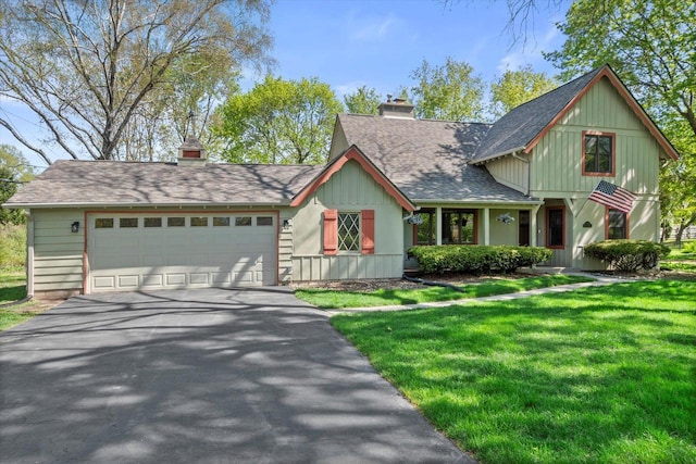 530 W Acacia Rd, Glendale, WI 53217 - view of front of property with a chimney, driveway, an attached garage, a front yard, and board and batten siding
