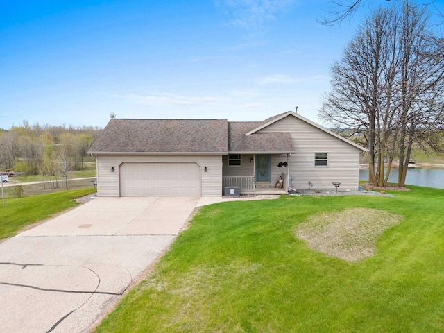 N3351 County Road B, Kewaunee, WI 54216 - view of front of house with a garage, a front yard, concrete driveway, and a water view