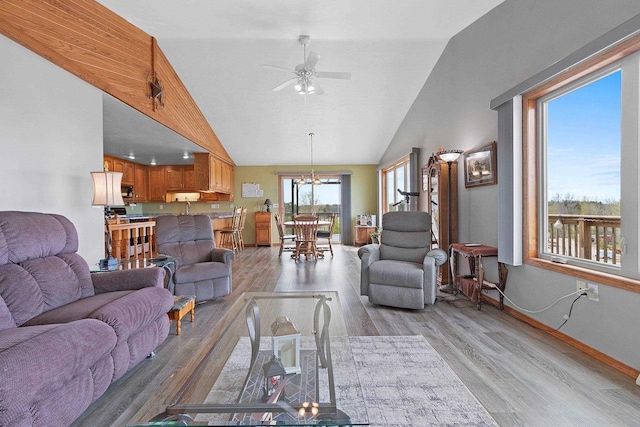 N3351 County Road B, Kewaunee, WI 54216 - living room featuring light wood finished floors, ceiling fan, baseboards, high vaulted ceiling, and a chandelier