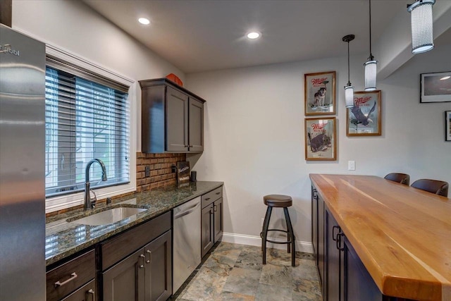 1002 Millies Way, Waunakee, WI 53597 - kitchen with a sink, appliances with stainless steel finishes, baseboards, tasteful backsplash, and wood counters