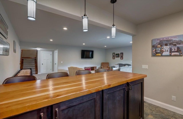 1002 Millies Way, Waunakee, WI 53597 - kitchen with wooden counters, baseboards, pendant lighting, open floor plan, and recessed lighting