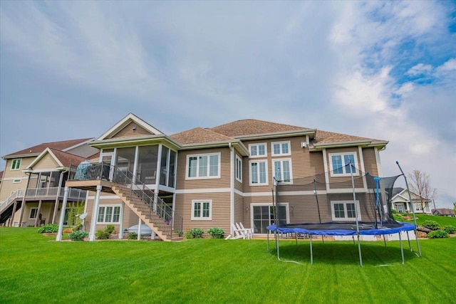 1002 Millies Way, Waunakee, WI 53597 - back of house featuring stairs, a sunroom, a trampoline, and a lawn