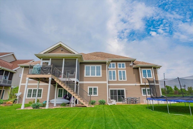 1002 Millies Way, Waunakee, WI 53597 - rear view of house with a trampoline, stairway, a sunroom, and a lawn