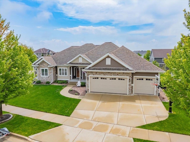1002 Millies Way, Waunakee, WI 53597 - craftsman-style home with an attached garage, a front lawn, concrete driveway, roof with shingles, and stone siding