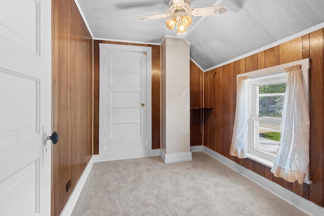 bonus room with wood walls, light colored carpet, ceiling fan, baseboards, and lofted ceiling