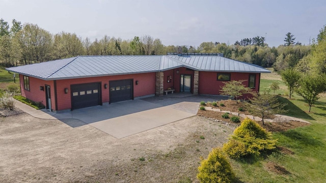 W7429 Akron Dr, Wild Rose, WI 54984 - view of front of home with a standing seam roof, driveway, metal roof, a garage, and a front lawn