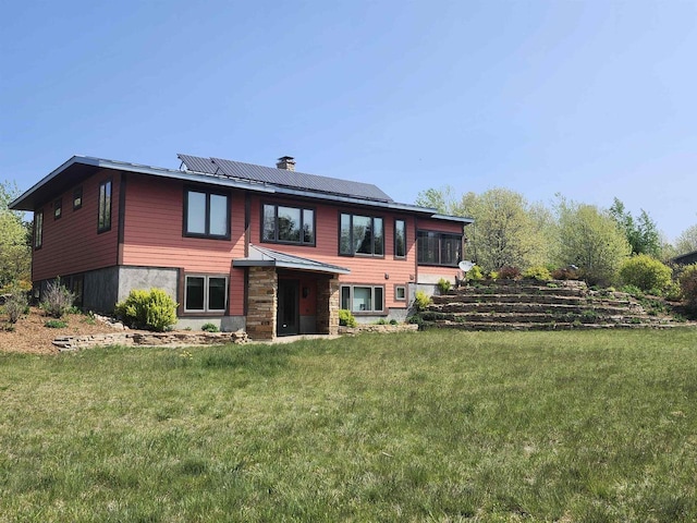 W7429 Akron Dr, Wild Rose, WI 54984 - rear view of house featuring solar panels, a lawn, and a chimney