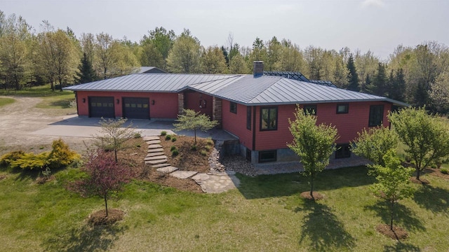 W7429 Akron Dr, Wild Rose, WI 54984 - view of property exterior featuring driveway, a garage, a standing seam roof, a lawn, and a chimney
