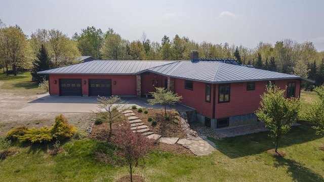 W7429 Akron Dr, Wild Rose, WI 54984 - view of front facade featuring a standing seam roof, concrete driveway, a garage, a chimney, and a front yard