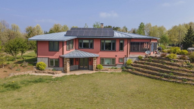 W7429 Akron Dr, Wild Rose, WI 54984 - rear view of house featuring a lawn, a chimney, roof mounted solar panels, and metal roof