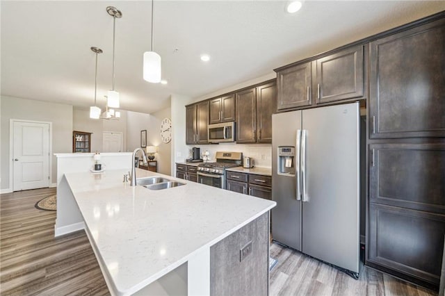 4271 Corn Silk Ln, Saint Paul, MN 55129 - kitchen with stainless steel appliances, a sink, light wood-type flooring, a large island with sink, and dark brown cabinets