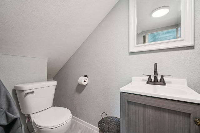 129 W 19th Ave, Oshkosh, WI 54902 - half bath featuring toilet, vanity, vaulted ceiling, wood finished floors, and baseboards