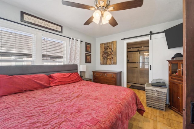 129 W 19th Ave, Oshkosh, WI 54902 - bedroom with light wood-style floors, multiple windows, a barn door, and a ceiling fan