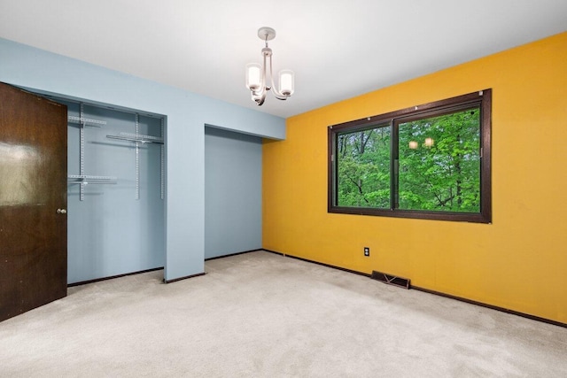 2734 Old Mill Dr Unit A-2, Racine, WI 53405 - unfurnished bedroom with two closets, carpet flooring, a chandelier, and baseboards