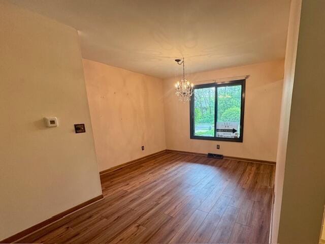 2734 Old Mill Dr Unit A-2, Racine, WI 53405 - unfurnished room with a chandelier, wood finished floors, and baseboards