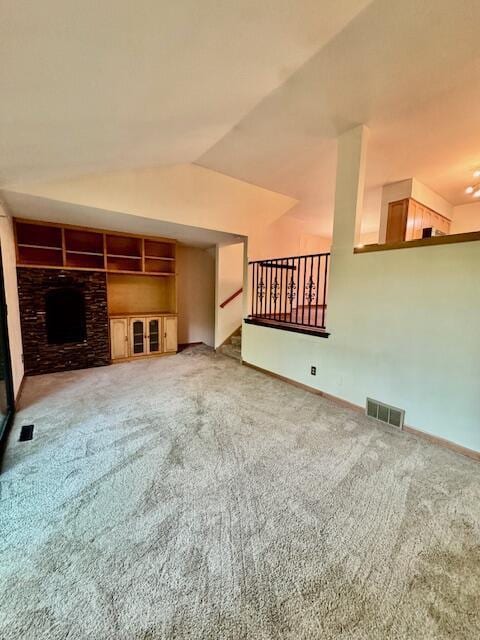 2734 Old Mill Dr Unit A-2, Racine, WI 53405 - unfurnished living room with carpet flooring, lofted ceiling, baseboards, a fireplace, and built in shelves