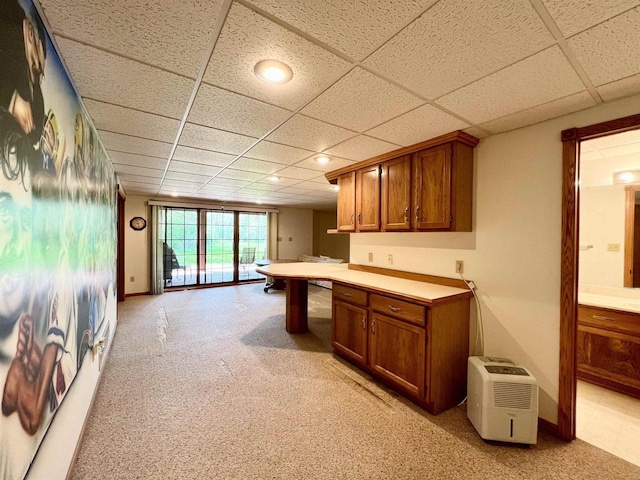 86 Ledgebrook Dr, Fond Du Lac, WI 54935 - kitchen with brown cabinets, light colored carpet, a paneled ceiling, and light countertops