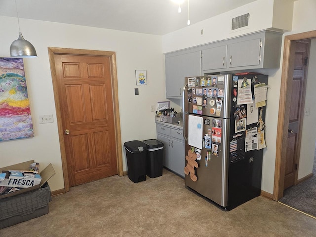 2416 N 69th St Unit 2418, Wauwatosa, WI 53213 - kitchen with freestanding refrigerator, gray cabinets, light colored carpet, and hanging light fixtures