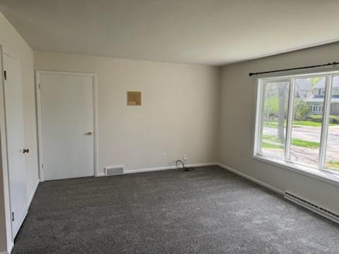 2416 N 69th St Unit 2418, Wauwatosa, WI 53213 - empty room with a baseboard heating unit, dark carpet, and baseboards