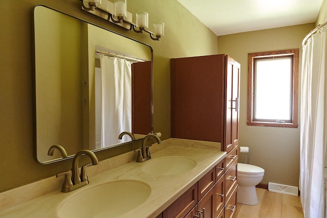 1810 W Upham Ct, Milwaukee, WI 53221 - bathroom with double vanity, toilet, and baseboards