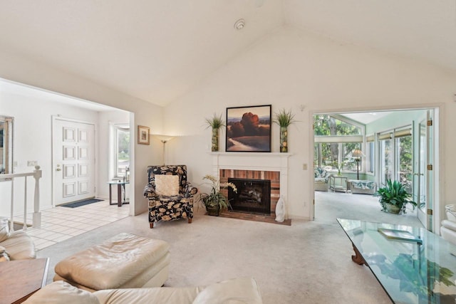 living room with carpet floors, a brick fireplace, and high vaulted ceiling