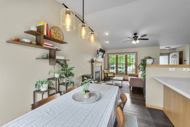 7217 Iris Bloom Dr, Madison, WI 53719 - dining space with a tiled fireplace, a ceiling fan, lofted ceiling, dark wood-style floors, and baseboards