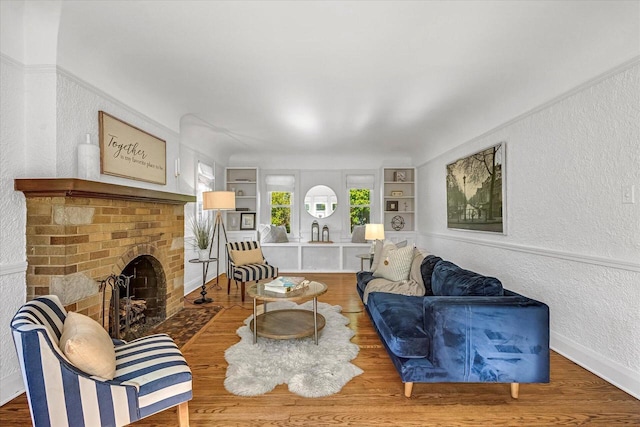 202 Lake Dr, South Milwaukee, WI 53172 - living area featuring a textured wall, wood finished floors, a fireplace, built in shelves, and baseboards