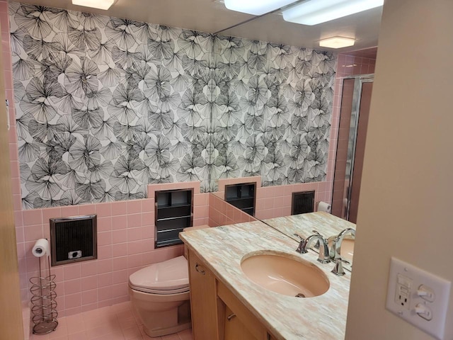 1610 N Prospect Ave Unit 506, Milwaukee, WI 53202 - bathroom with tile walls, a stall shower, toilet, tile patterned floors, and vanity
