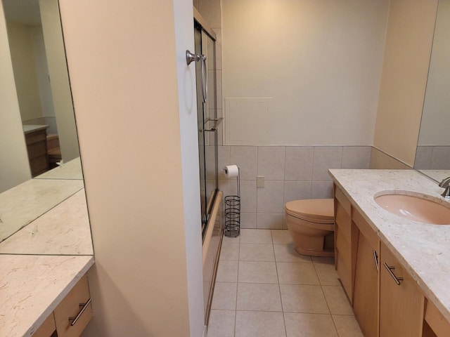 1610 N Prospect Ave Unit 506, Milwaukee, WI 53202 - bathroom with vanity, toilet, tile walls, tile patterned flooring, and shower / bath combination with glass door