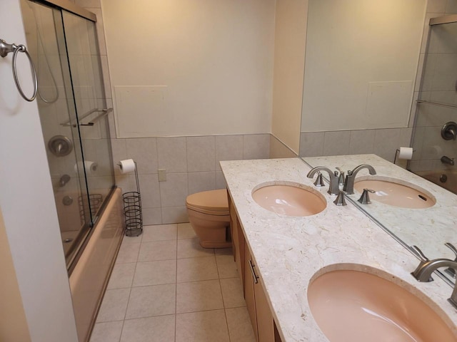 1610 N Prospect Ave Unit 506, Milwaukee, WI 53202 - full bath with tile walls, toilet, bath / shower combo with glass door, tile patterned flooring, and double vanity