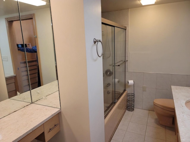 1610 N Prospect Ave Unit 506, Milwaukee, WI 53202 - full bath featuring vanity, tile patterned floors, tile walls, shower / bath combination with glass door, and toilet
