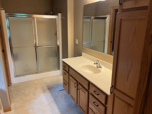 1030 Woodland Ct, Plover, WI 54467 - full bath featuring a stall shower, vanity, and tile patterned flooring