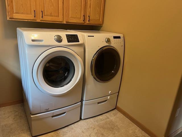1030 Woodland Ct, Plover, WI 54467 - washroom with washing machine and clothes dryer, cabinet space, and baseboards