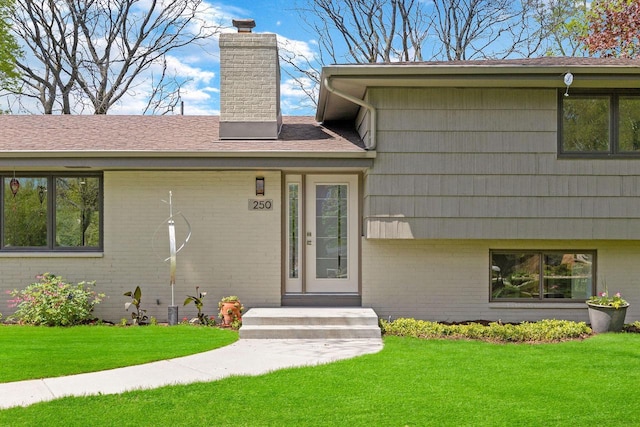 250 W Suburban Ct, Fox Point, WI 53217 - entrance to property featuring a chimney, brick siding, and a lawn