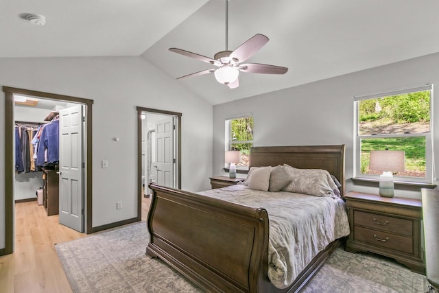 S7698 Grandview Ave, Merrimac, WI 53561 - bedroom featuring a walk in closet, vaulted ceiling, light wood-type flooring, a closet, and a ceiling fan