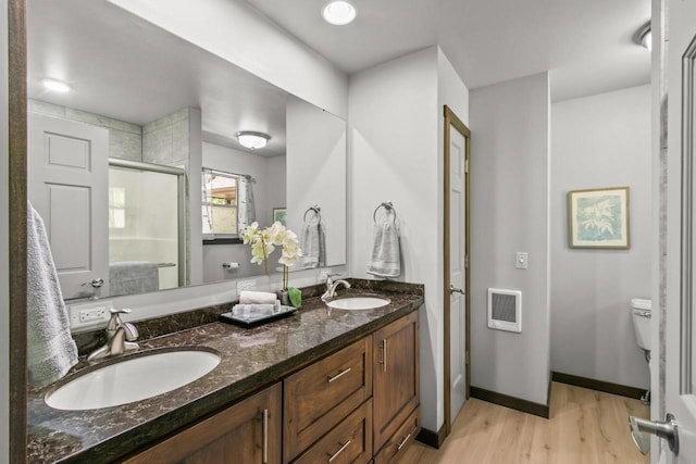 S7698 Grandview Ave, Merrimac, WI 53561 - full bath with wood finished floors, a shower stall, toilet, double vanity, and heating unit