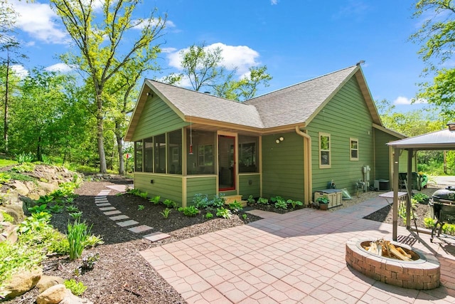 S7698 Grandview Ave, Merrimac, WI 53561 - back of house featuring a sunroom, an outdoor fire pit, a patio, a shingled roof, and a gazebo