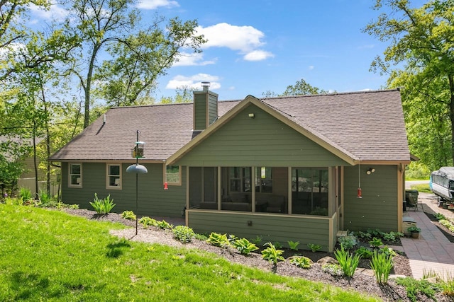 S7698 Grandview Ave, Merrimac, WI 53561 - rear view of house with a sunroom, a chimney, roof with shingles, and a yard