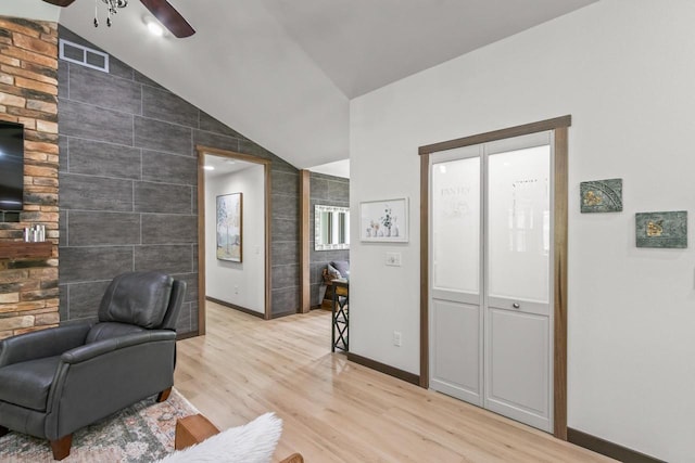 S7698 Grandview Ave, Merrimac, WI 53561 - living room with vaulted ceiling, light wood-type flooring, a ceiling fan, baseboards, and tile walls